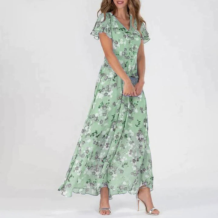 Groene maxi zomerjurk met korte mouwen, een lange snit en een vrolijke bloemenprint